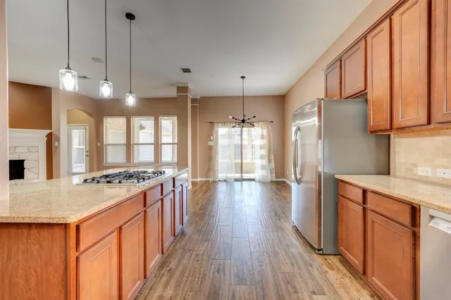 a kitchen with stainless steel appliances granite countertop wooden floors stove and refrigerator