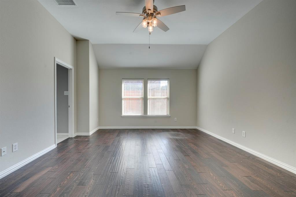 7519 Forest Ridge Trail Sachse, TX 75048 - Photo 22 of 35 an empty room with wooden floor chandelier fan and windows