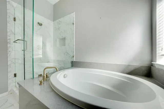 a white bath tub sitting in a bathroom next to a window