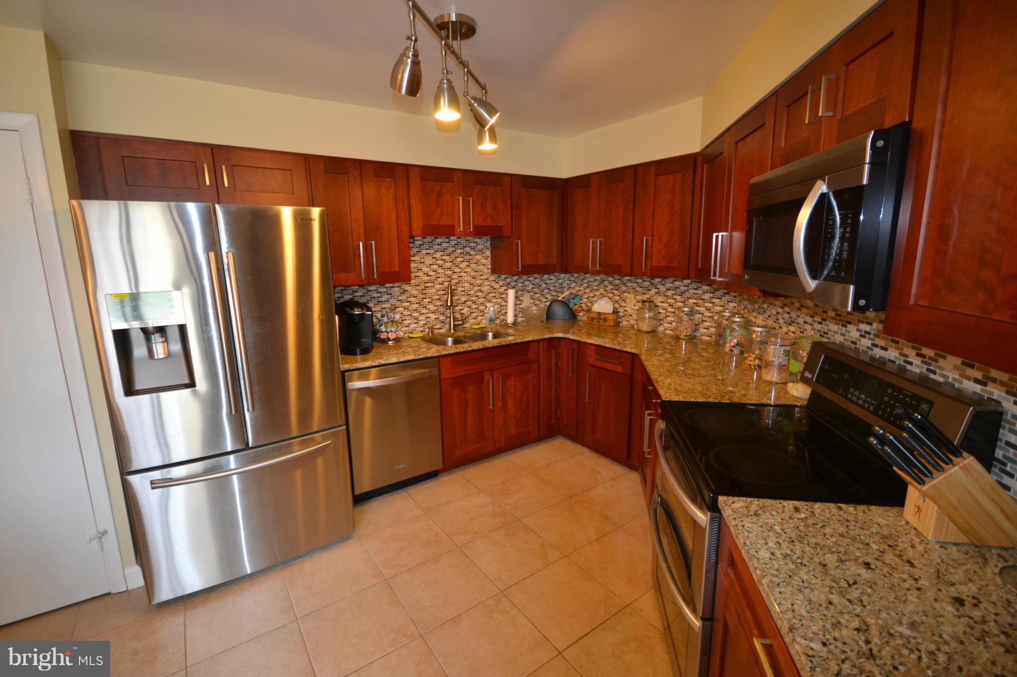3011 Fallstaff Road, Unit 301A Baltimore, MD 21209 - Photo 14 of 25 a kitchen with stainless steel appliances granite countertop a refrigerator a sink a stove and island
