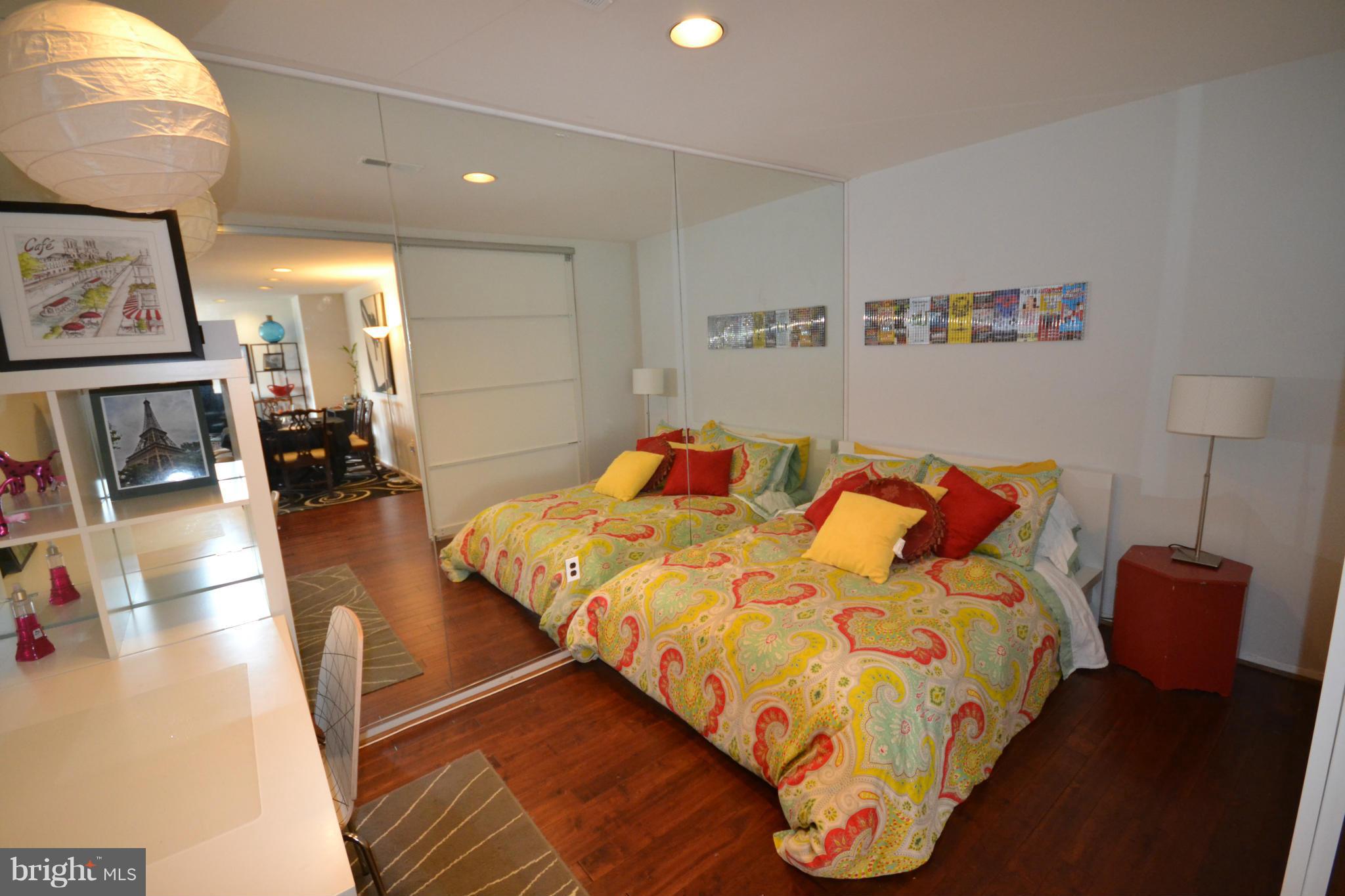3011 Fallstaff Road, Unit 301A Baltimore, MD 21209 - Photo 8 of 25 a bed sitting in a bedroom next to a lamp on a rug and a chandelier