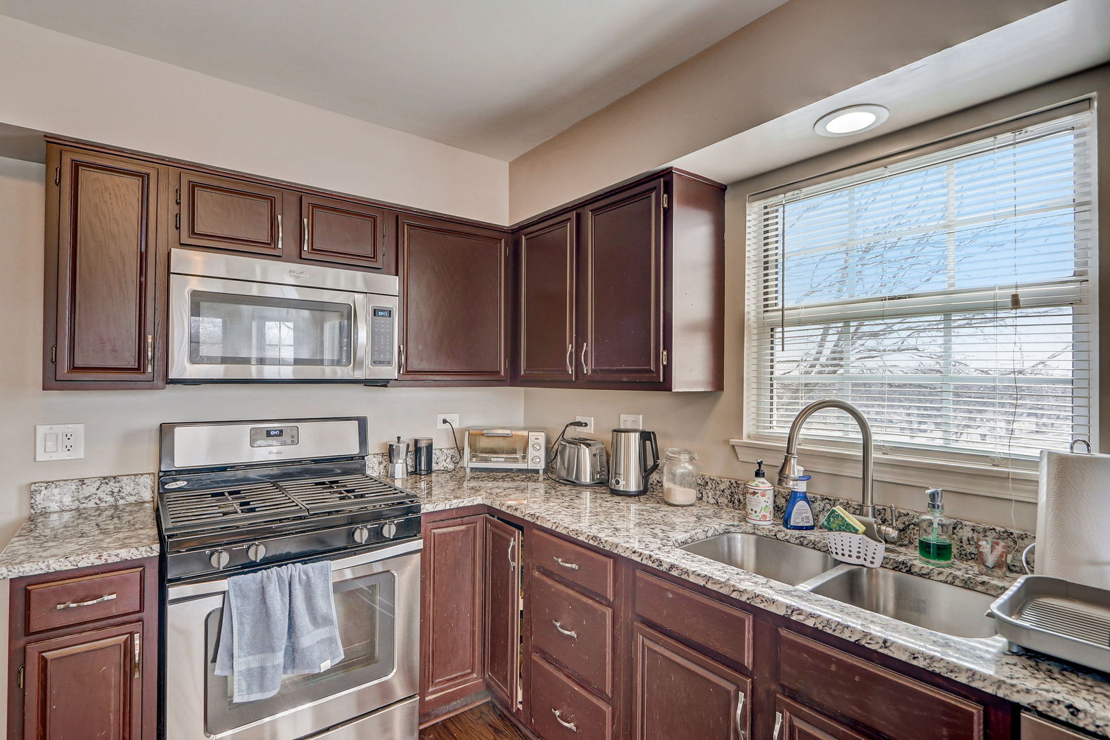 628 Village Road, Unit B Crystal Lake, IL 60014 - Photo 11 of 33 a kitchen with granite countertop a stove a sink and a microwave