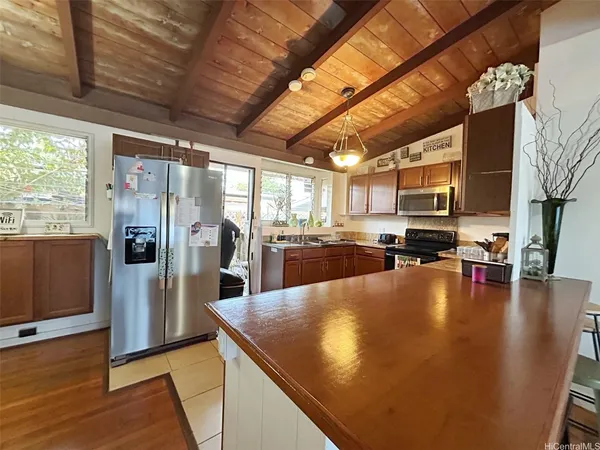 a living room with stainless steel appliances furniture stove and a kitchen view