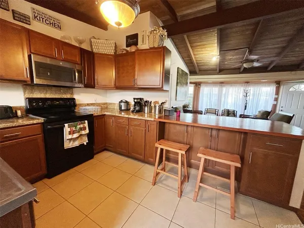 a kitchen with stainless steel appliances granite countertop a sink a stove a microwave with a dining table and chairs