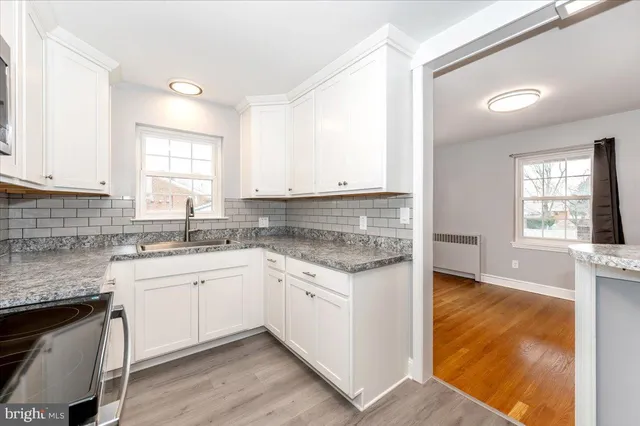 a kitchen with granite countertop a sink and cabinets