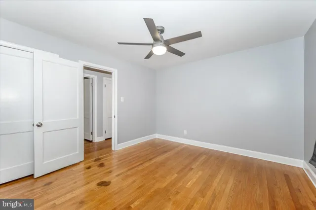 an empty room with wooden floor door and windows