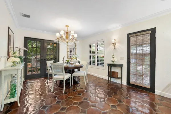 a dining room with chandelier and wooden floor