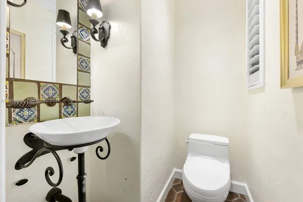 a white toilet sitting next to a bathroom sink
