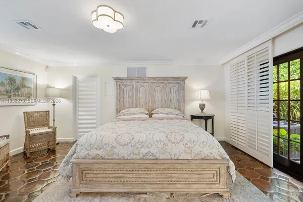 a spacious bedroom with a bed and a lamp