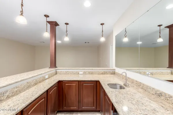 a bathroom with a granite countertop sink and mirror