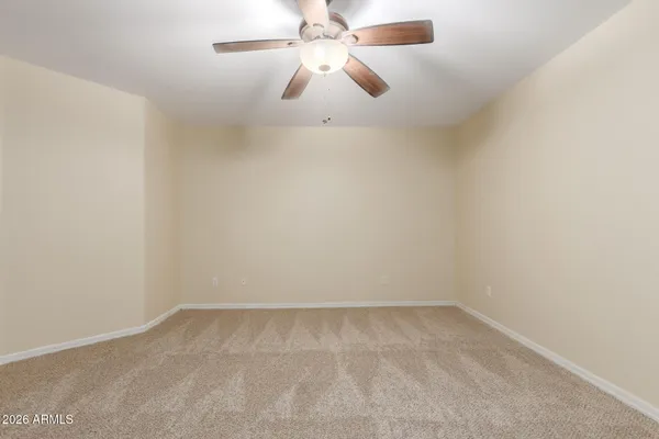 an empty room with a ceiling fan and fan
