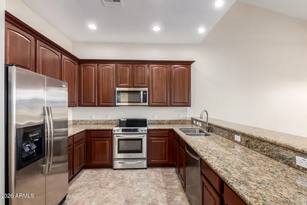 a kitchen with stainless steel appliances granite countertop a sink stove and refrigerator