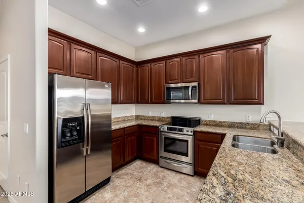 a kitchen with stainless steel appliances granite countertop a refrigerator stove and sink