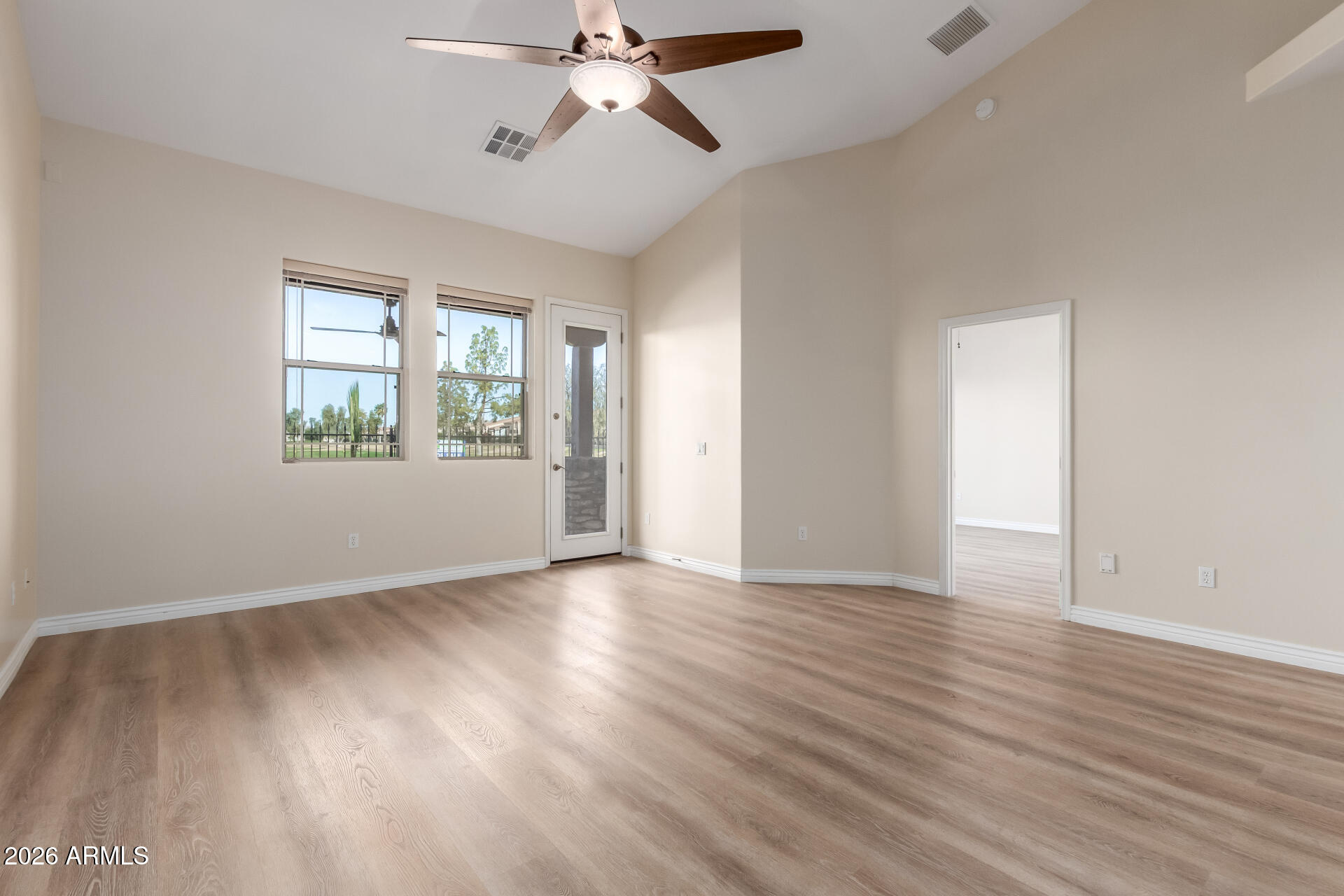 6202 East McKellips Road, Unit 115 Mesa, AZ 85215 - Photo 7 of 43 a view of an empty room with wooden floor and a window