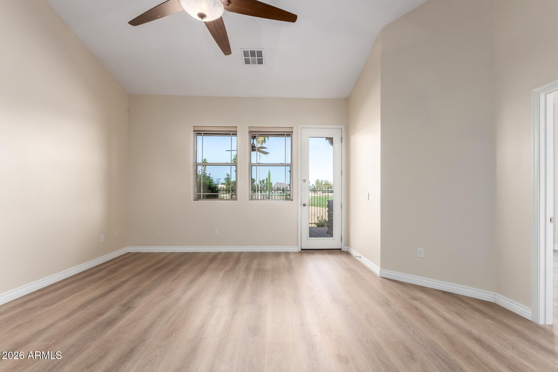 6202 East McKellips Road, Unit 115 Mesa, AZ 85215 - Photo 8 of 43 an empty room with wooden floor chandelier fan and windows
