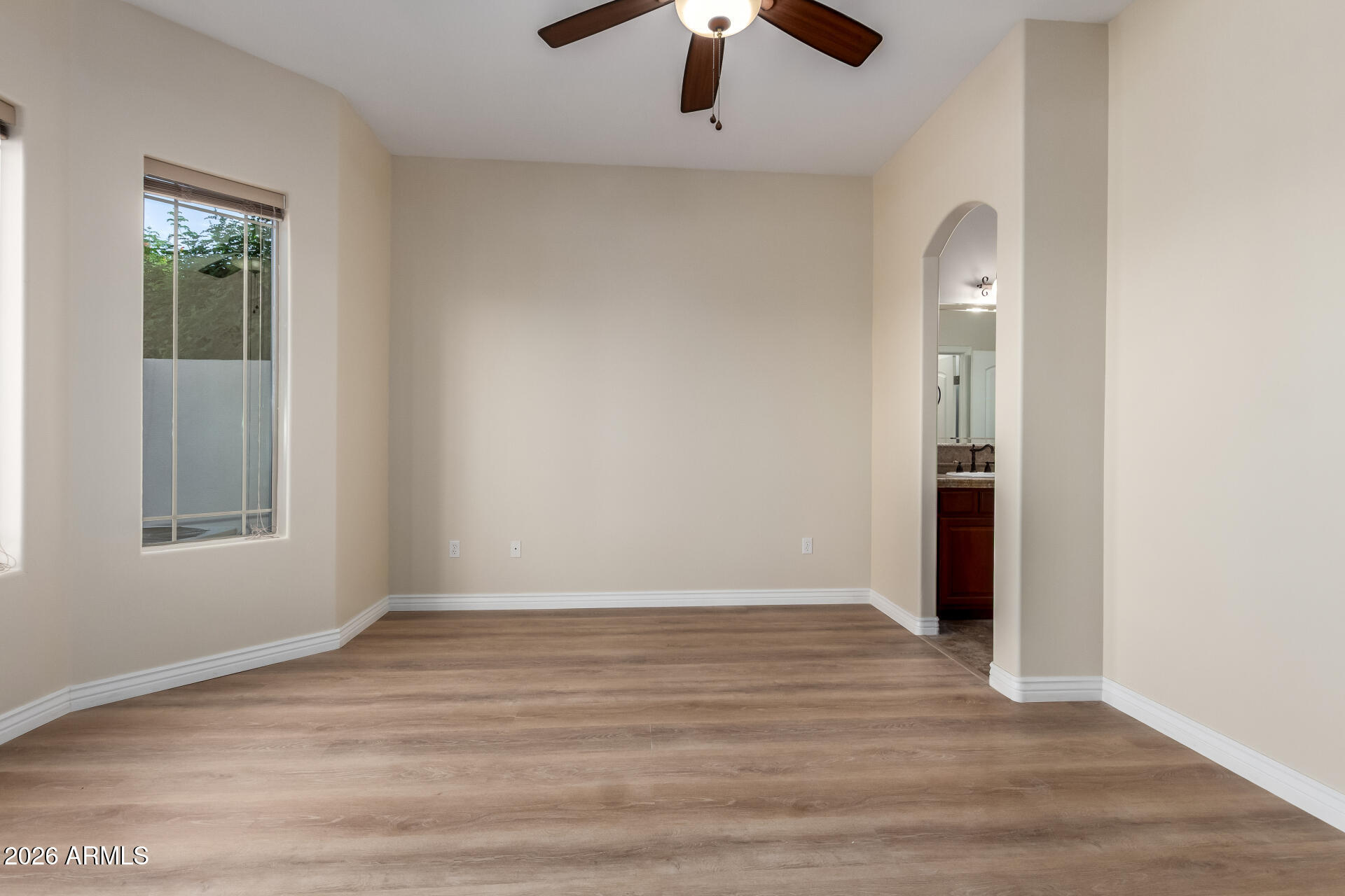 6202 East McKellips Road, Unit 115 Mesa, AZ 85215 - Photo 9 of 43 an empty room with wooden floor chandelier fan and windows