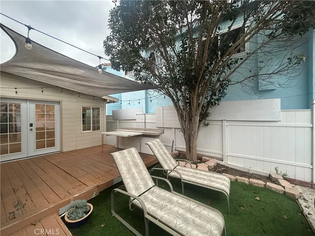 a roof deck with table and chairs and potted plants