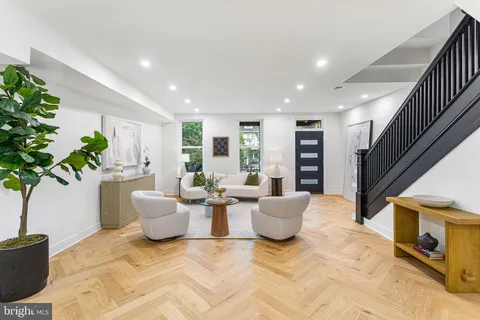 a living room with fireplace furniture and a potted plant