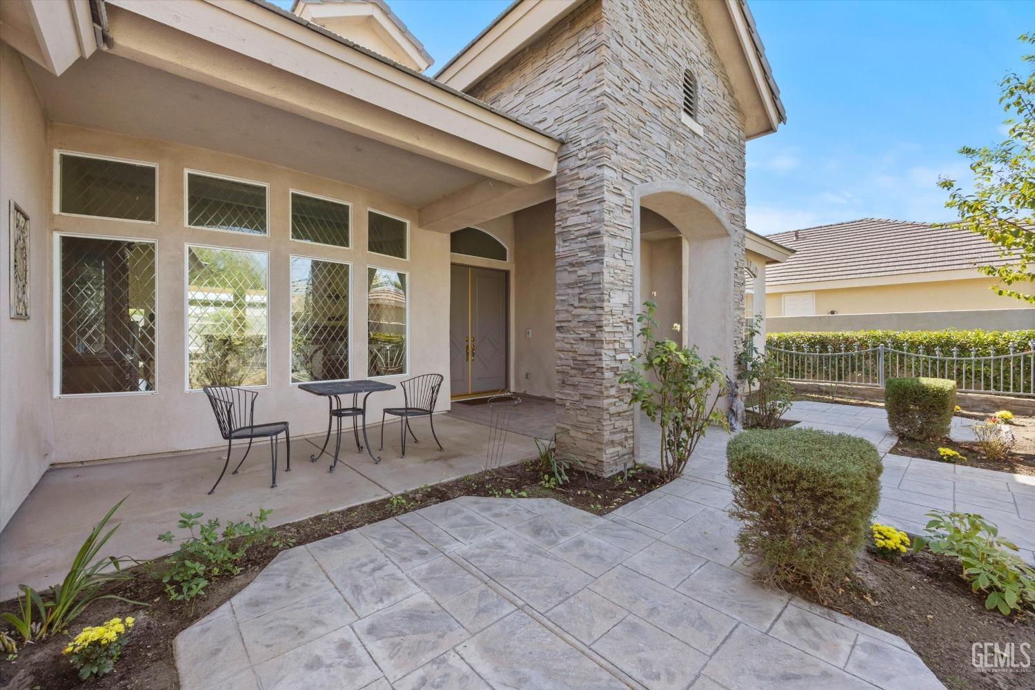 Undisclosed Address Bakersfield, CA 93312 - Photo 12 of 50 a view of a patio with table and chairs potted plants and floor to ceiling window