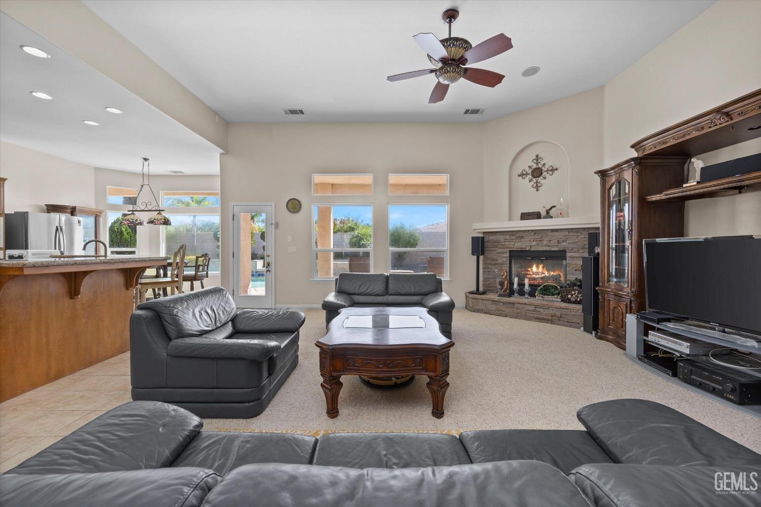 Undisclosed Address Bakersfield, CA 93312 - Photo 16 of 50 a living room with furniture a flat screen tv and a fireplace