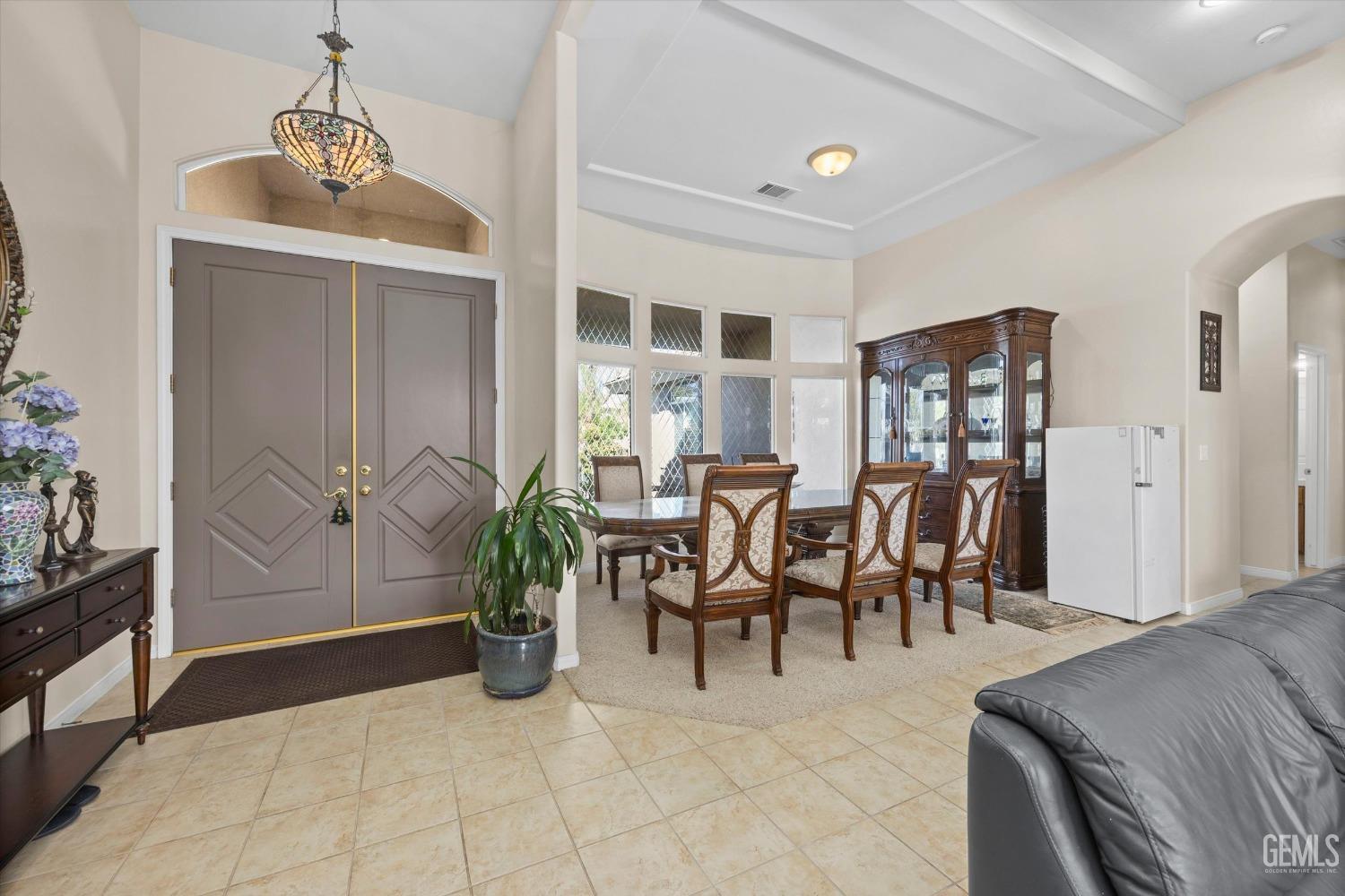 Undisclosed Address Bakersfield, CA 93312 - Photo 18 of 50 a living room with furniture a chandelier and a dining table