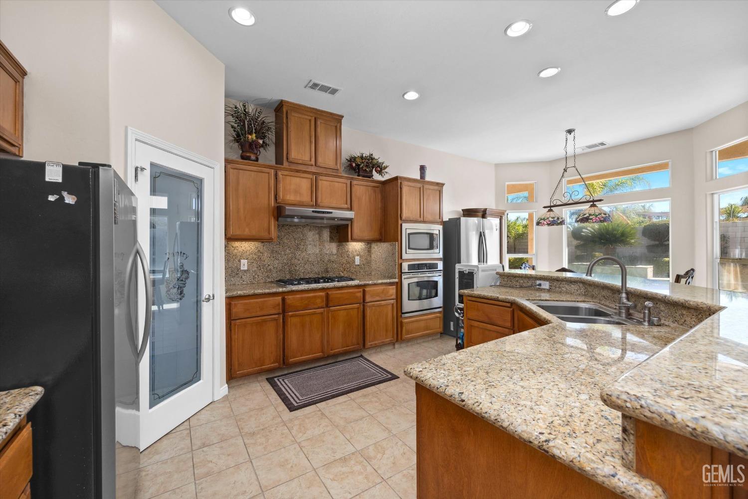 Undisclosed Address Bakersfield, CA 93312 - Photo 25 of 50 a kitchen with stainless steel appliances granite countertop a sink and a refrigerator