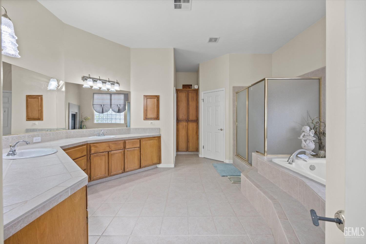 Undisclosed Address Bakersfield, CA 93312 - Photo 29 of 50 a spacious bathroom with a tub sink and mirror