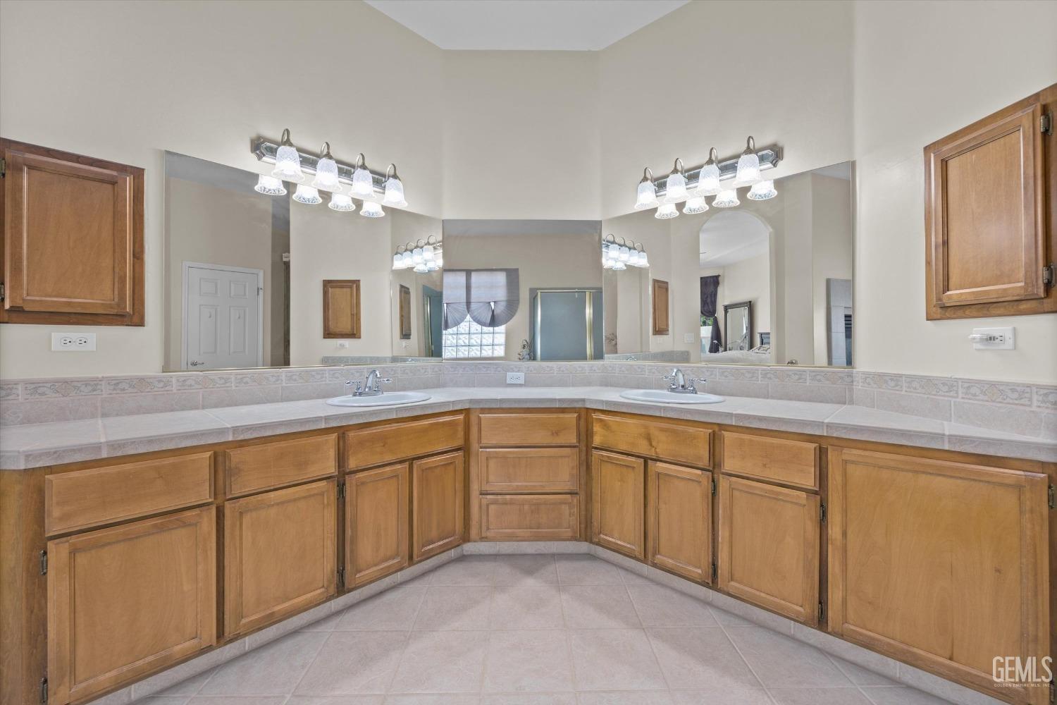 Undisclosed Address Bakersfield, CA 93312 - Photo 30 of 50 a spacious en suite bathroom with a double vanity sink and a mirror