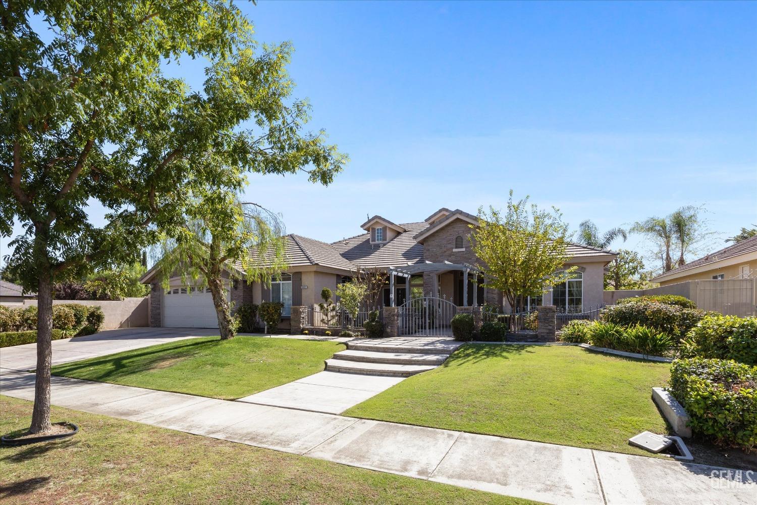 Undisclosed Address Bakersfield, CA 93312 - Photo 3 of 50 a front view of a house with a yard and large trees