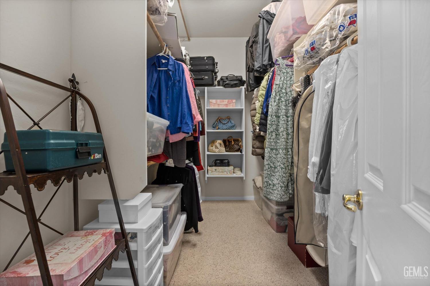 Undisclosed Address Bakersfield, CA 93312 - Photo 34 of 50 a view of walk in closet with clothes and shoes