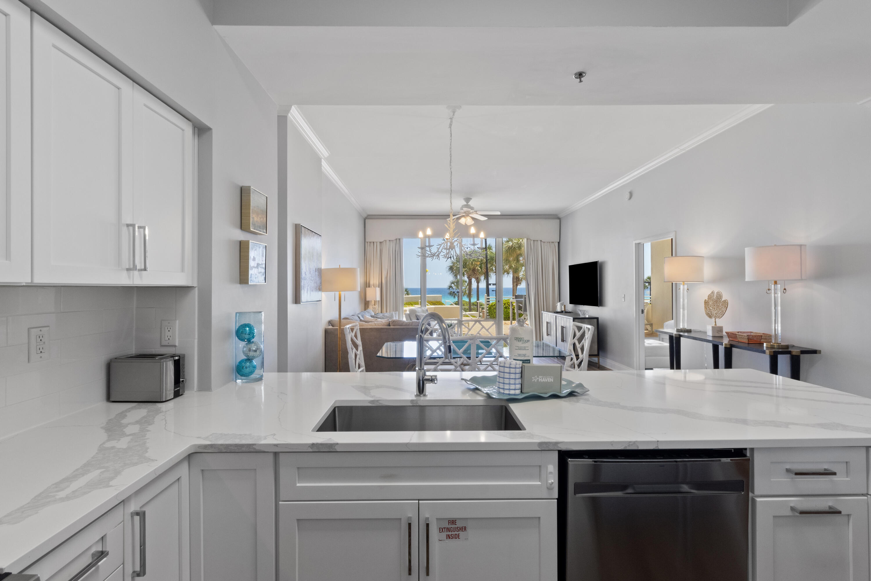 550 Tops'l Beach Boulevard, Unit 103 Miramar Beach, FL 32550 - Photo 5 of 20 a kitchen with a sink and white cabinets