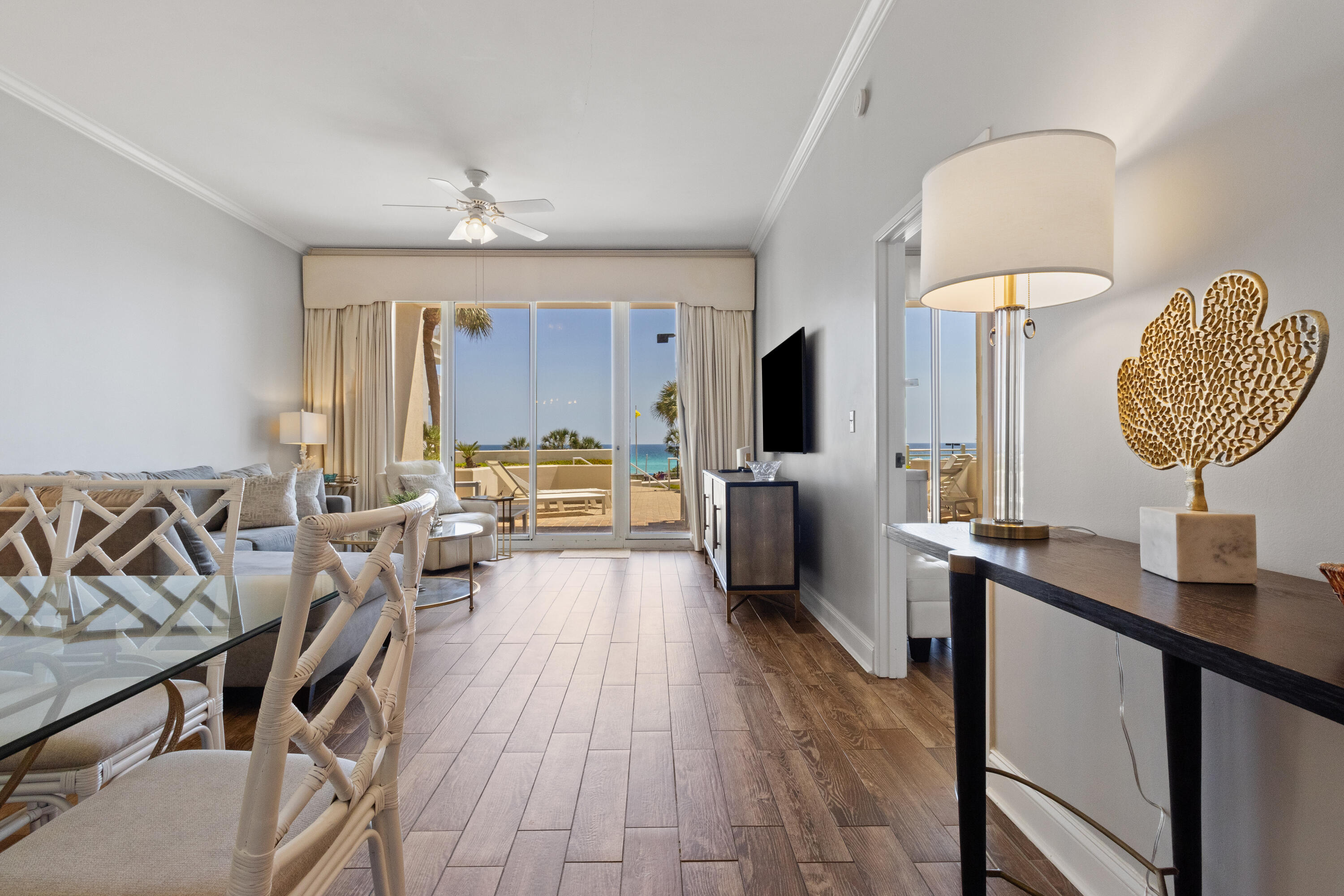 550 Tops'l Beach Boulevard, Unit 103 Miramar Beach, FL 32550 - Photo 7 of 20 a living room with furniture a chandelier a large window and flat screen tv