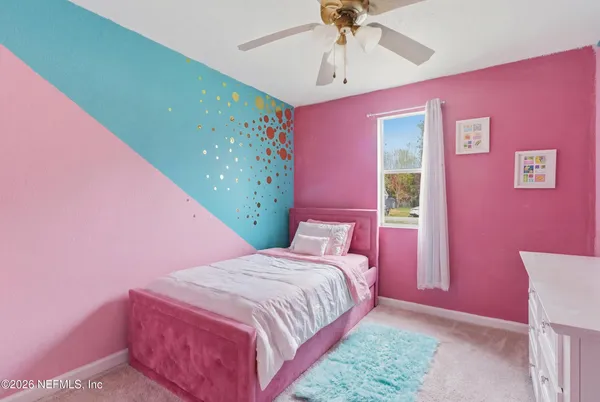 a bedroom with a bed mirror and a window
