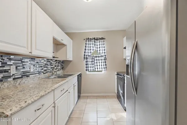 a kitchen with a refrigerator sink and cabinets