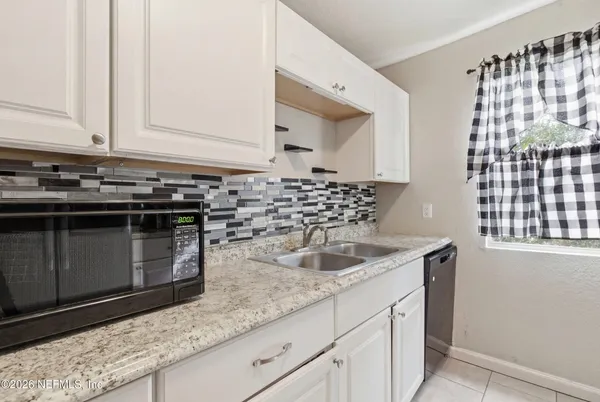 a kitchen with granite countertop a sink and a stove