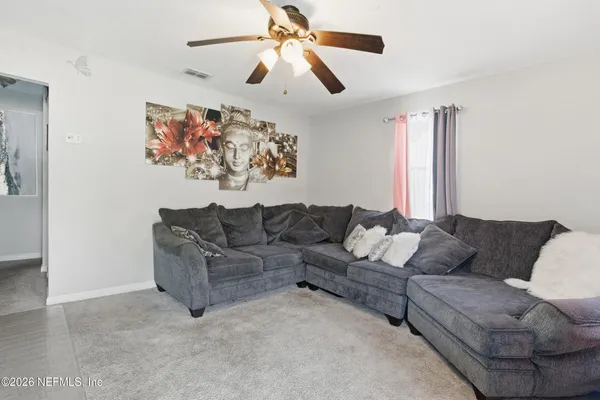 a living room with furniture ceiling fan and a rug