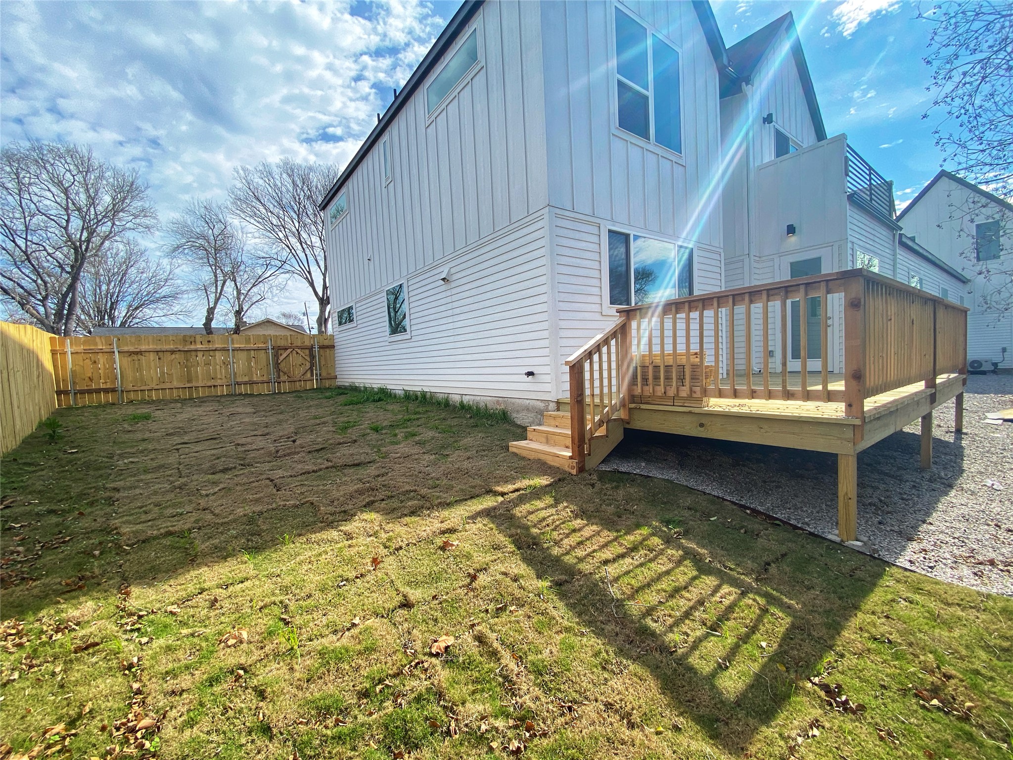 1916 Webberville Road, Unit B Austin, TX 78721 - Photo 25 of 25 Private backyard featuring a newly installed wooden privacy fence and a spacious wooden deck with staircase access