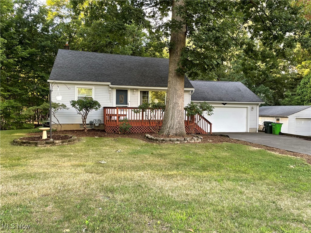 3389 Eastern Road Barberton, OH 44203 - Photo 1 of 1 View of front of home featuring a garage, a front lawn, a deck, and an outdoor structure