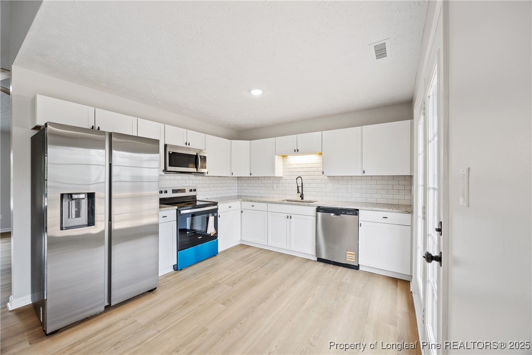 122 Tanner Loop Raeford, NC 28376 - Photo 11 of 36 a kitchen with a refrigerator cabinets and wooden floor