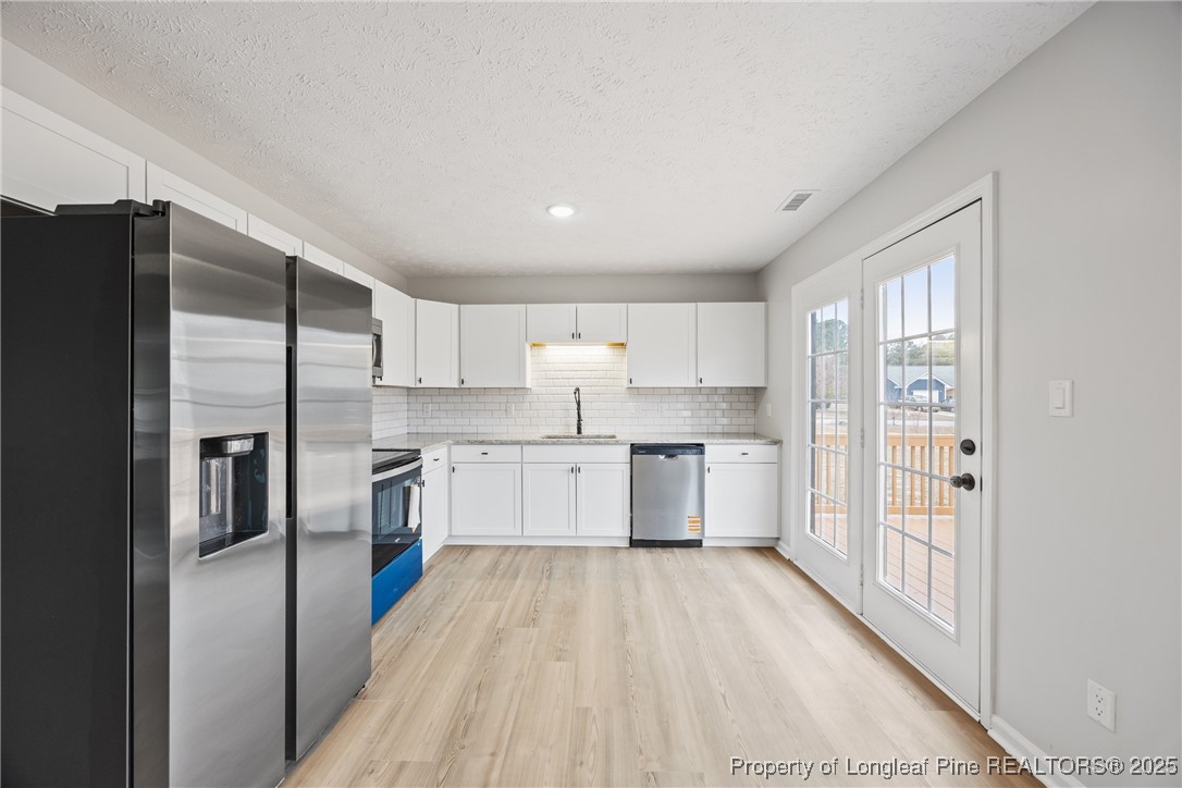 122 Tanner Loop Raeford, NC 28376 - Photo 12 of 36 a kitchen with a refrigerator a sink and cabinets