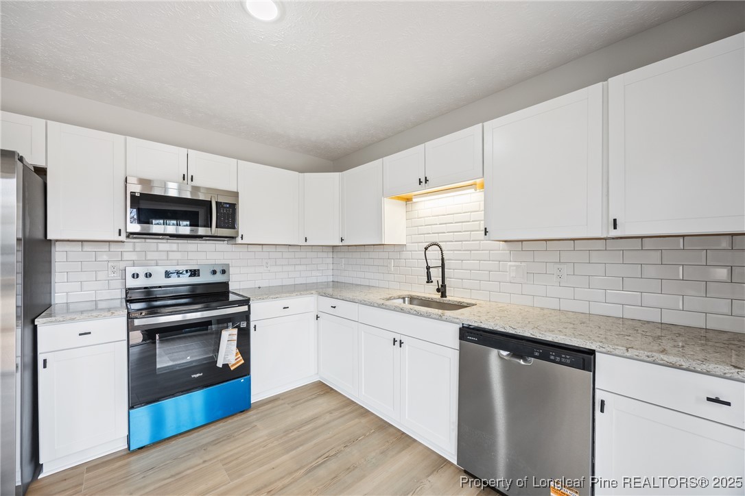 122 Tanner Loop Raeford, NC 28376 - Photo 13 of 36 a kitchen with stainless steel appliances granite countertop a sink stove and microwave