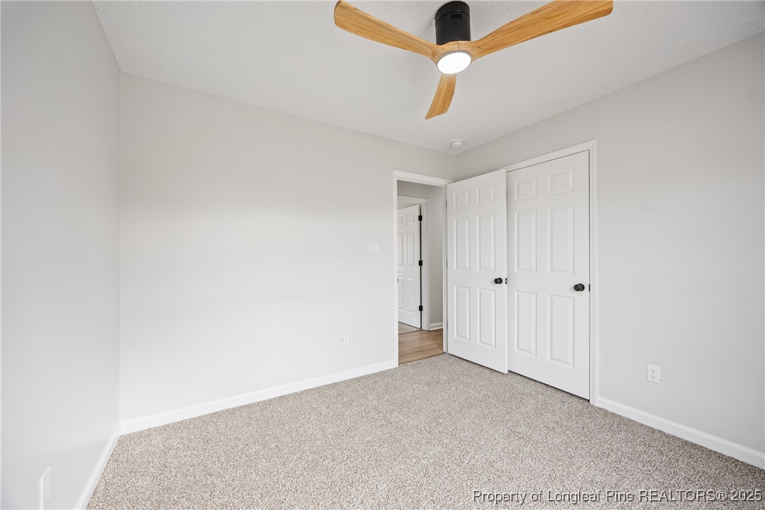 122 Tanner Loop Raeford, NC 28376 - Photo 28 of 36 an empty room with a ceiling fan and carpet