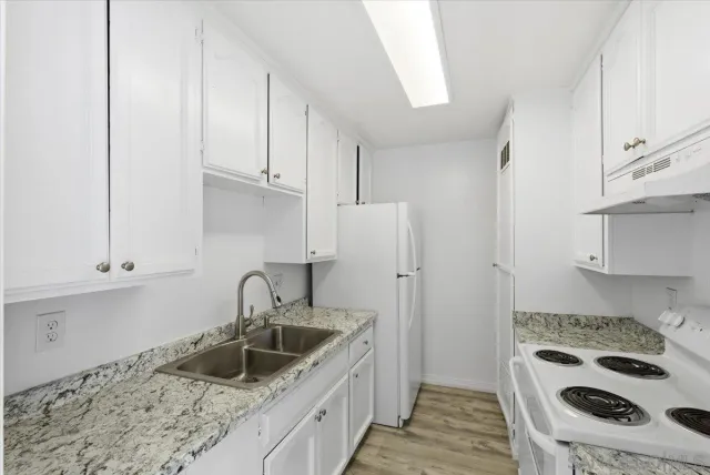 a bathroom with a granite countertop toilet sink and mirror