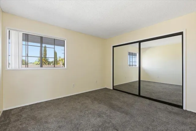 an empty room with wooden floor and a ceiling fan