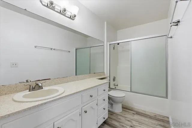 a view of a livingroom with wooden floor and a ceiling fan