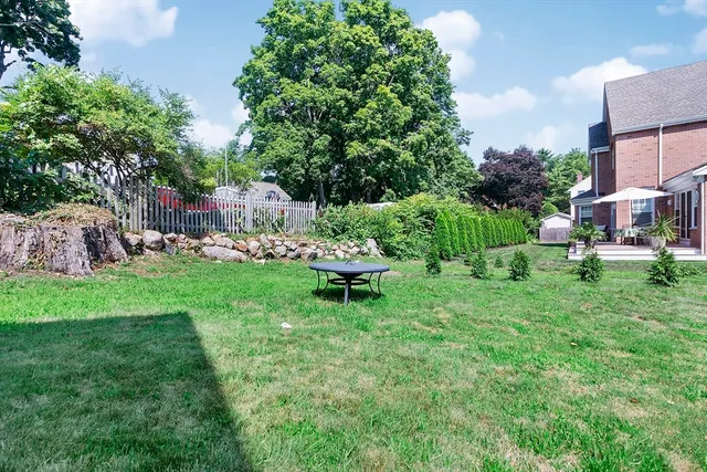 a view of a chair and table in backyard of the house