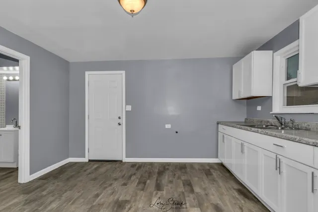 a view of kitchen with granite countertop cabinets and sink