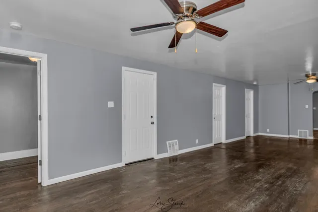 an empty room with closet and windows
