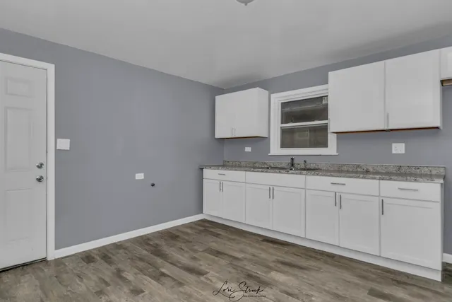 a kitchen with granite countertop white cabinets and a granite counter top
