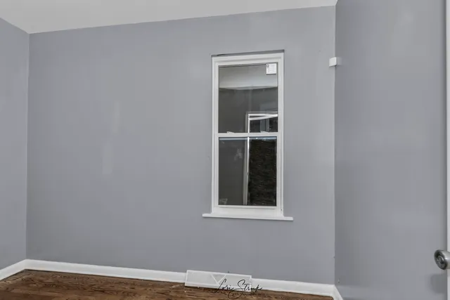 a view of a small space with wooden floor and a window